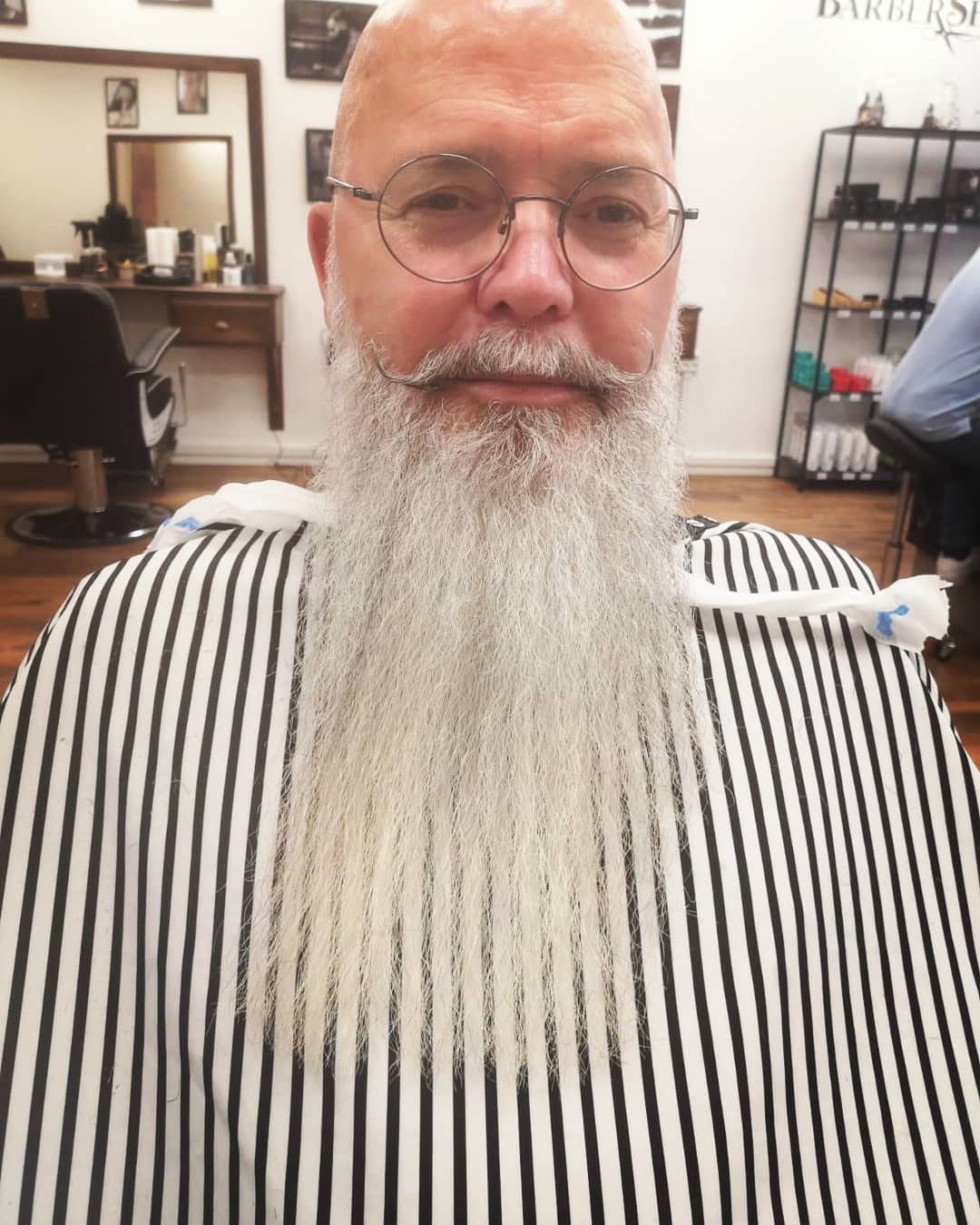 Kund med långt vitt helskägg och formad mustasch