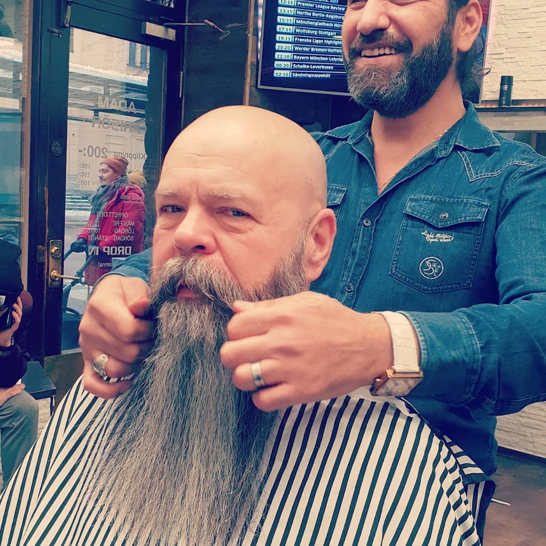 Ziad formar ett långt gråsprängt helskägg med vaxad handlebar-mustasch